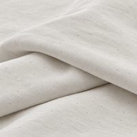 Close-up of the undyed organic cotton fabric, with natural flecks in the weave